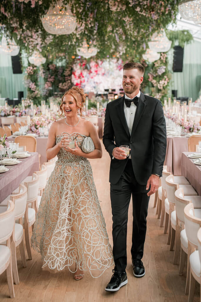 Bride in Oscar de la Renta gown and groom in Ralph Lauren tuxedo walking through their elegant Las Vegas wedding reception at the Smith Center. 