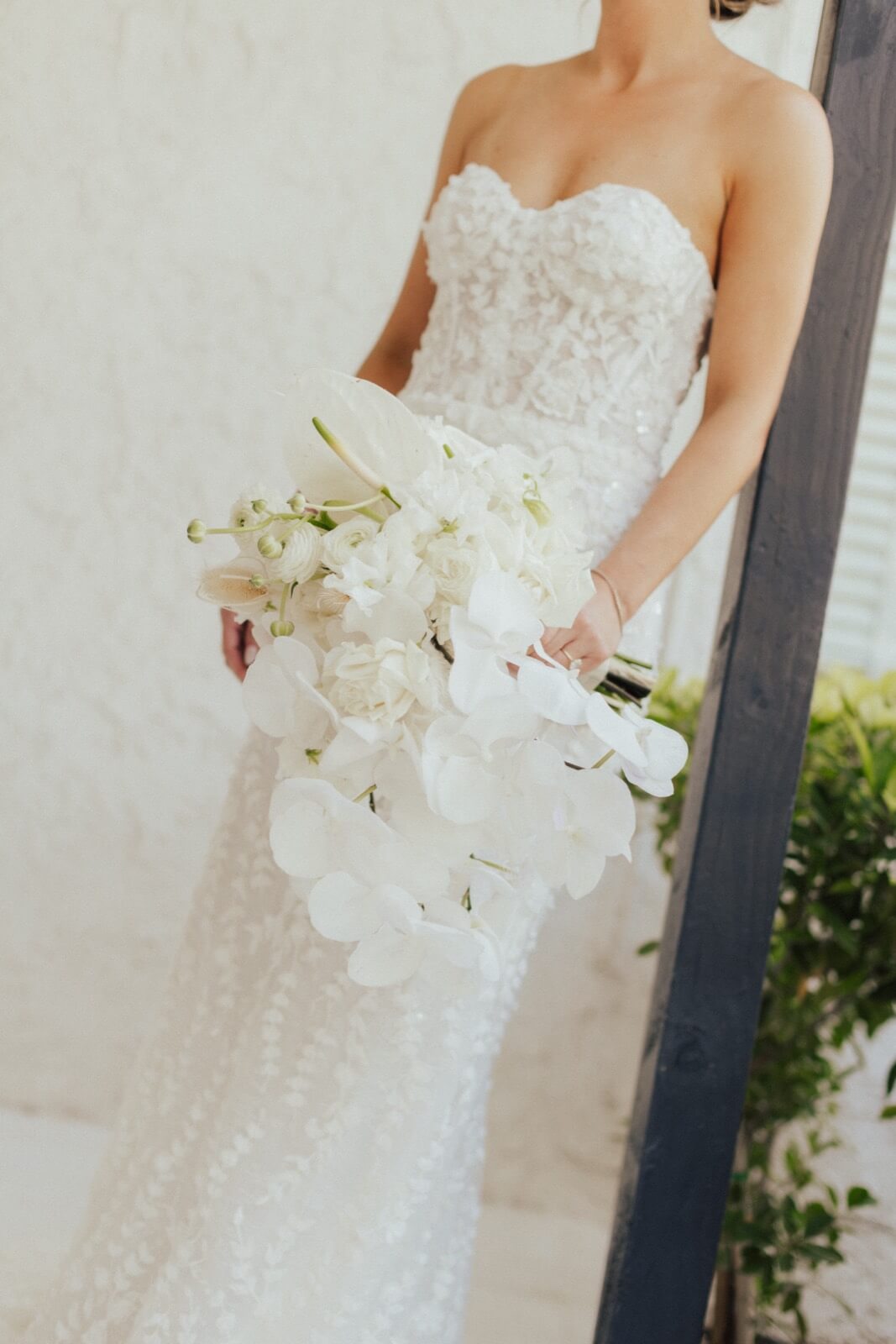 Modern Palm Springs Wedding | bride in a lace gown with a white orchid bouquet